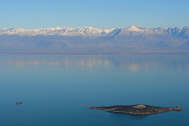 Трудно жить среди такой фантастической красоты и не верить в бога. На снимке: Скадарское озеро и черногорские острова с монастырём на одном из них. На том берегу — албанский город Шкодер (Скадар)